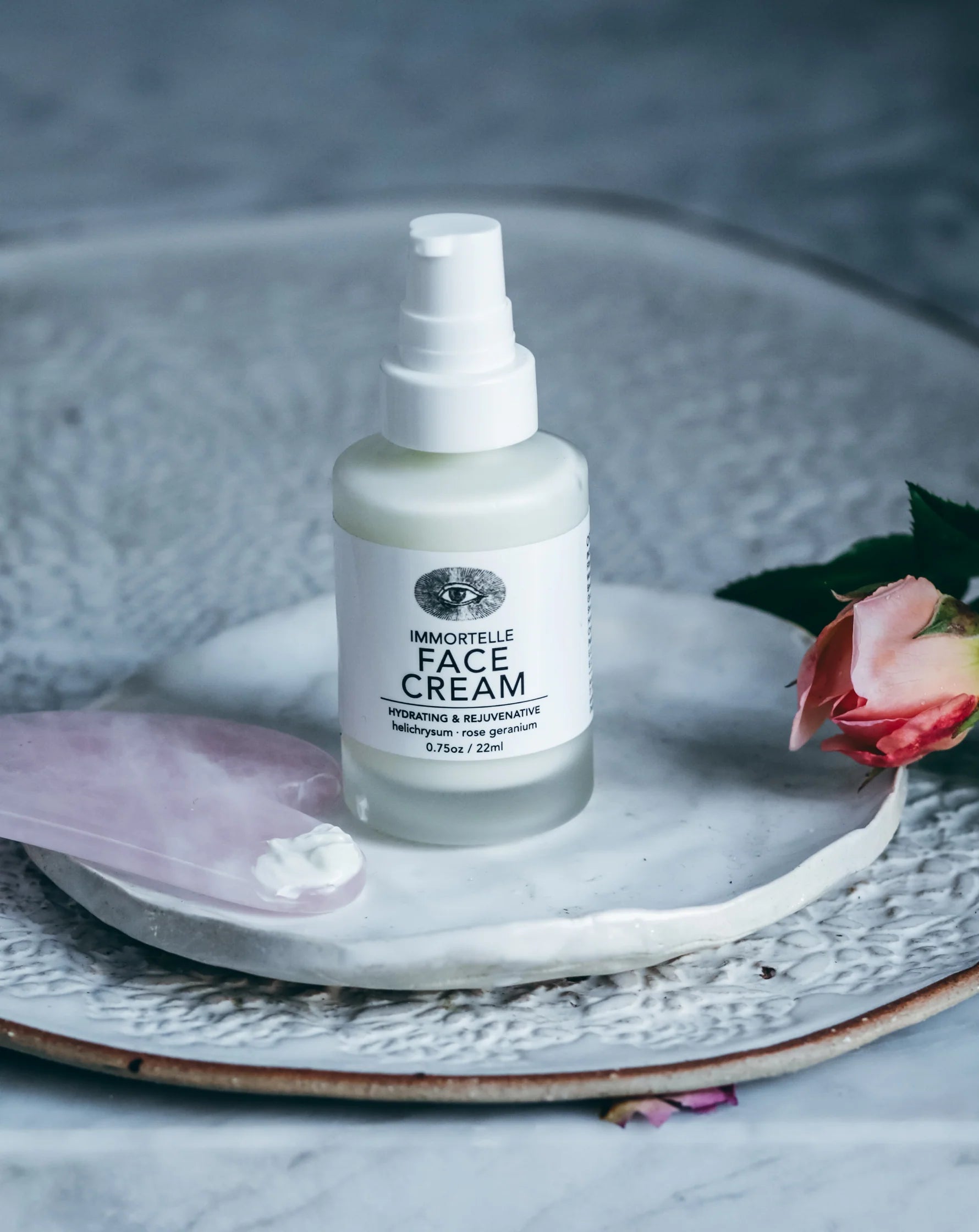 Bottle of face cream on a decorative plate with a rose