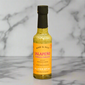 Bottle of Raw & Hot Jalapeño Chilli Sauce on a marble background