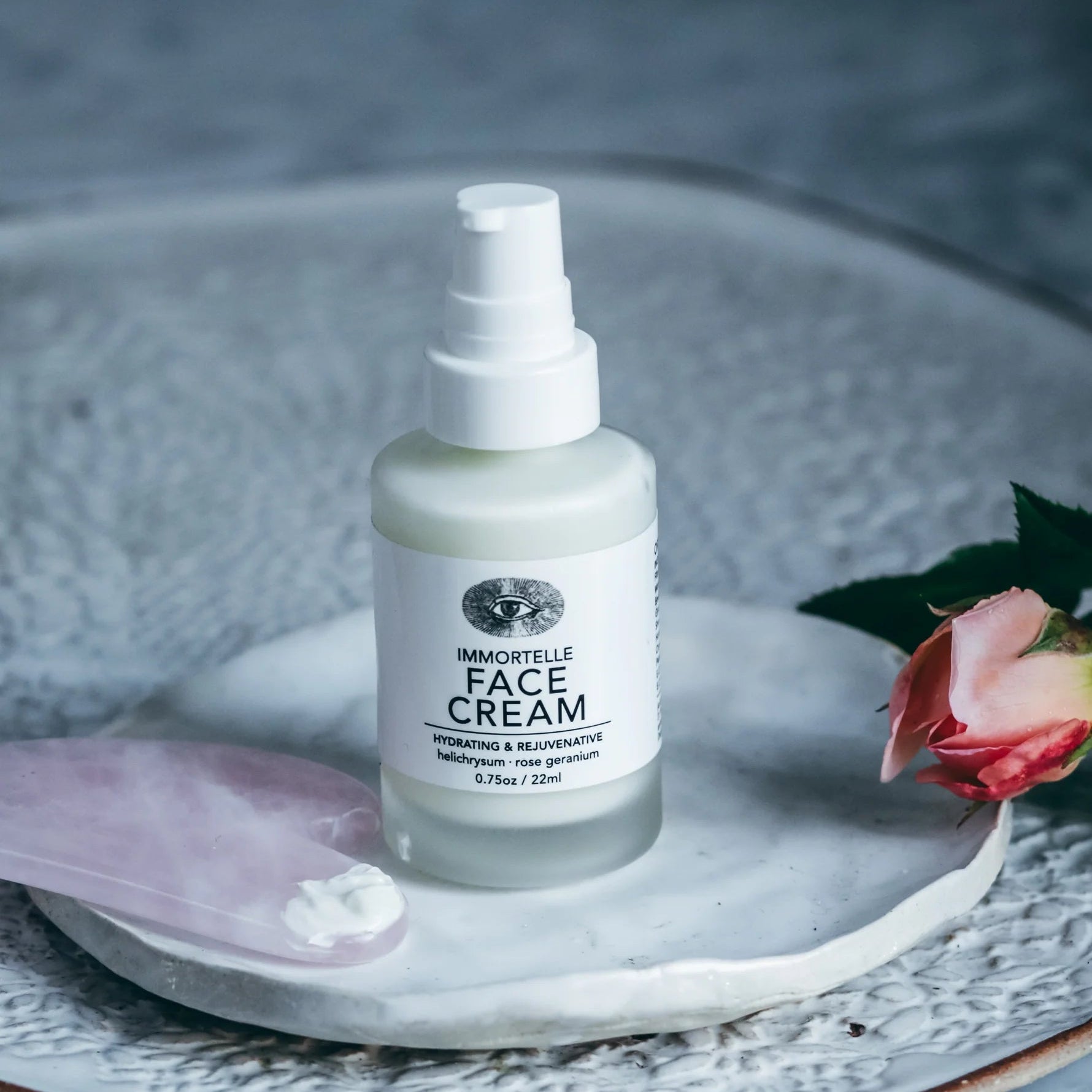 Bottle of face cream on a decorative plate with a rose