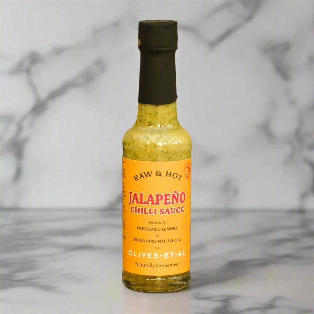 Bottle of Raw &amp; Hot Jalapeño Chilli Sauce on a marble background