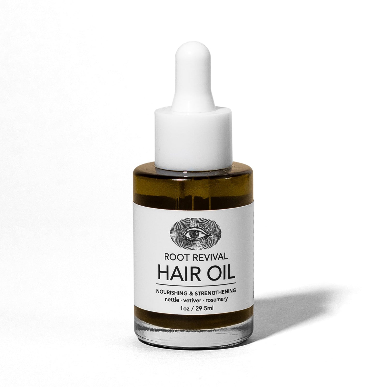 Hair oil bottle with dropper labeled 'Root Revival Hair Oil' on a white background