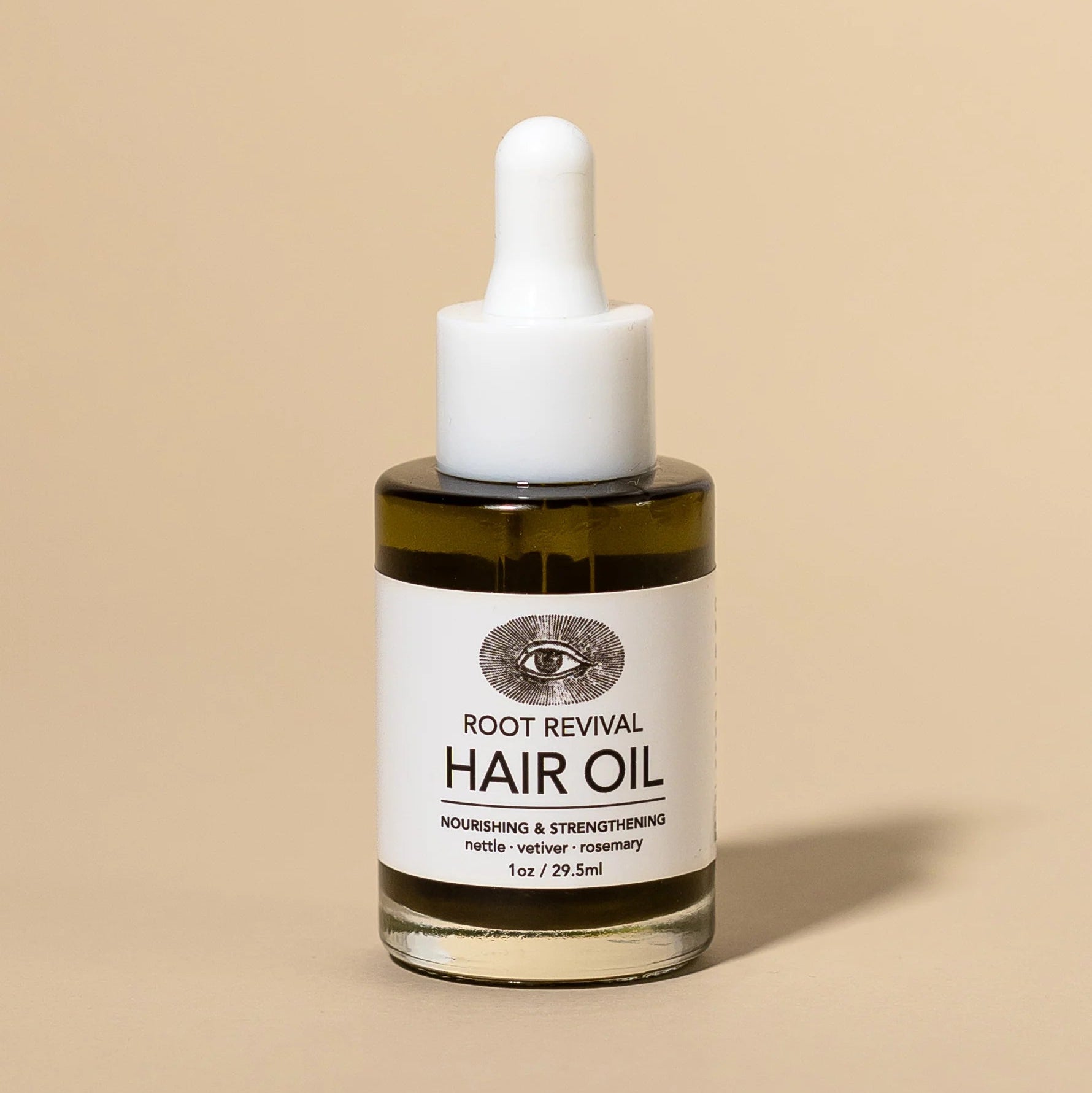 Hair oil dropper bottle with label on a beige background