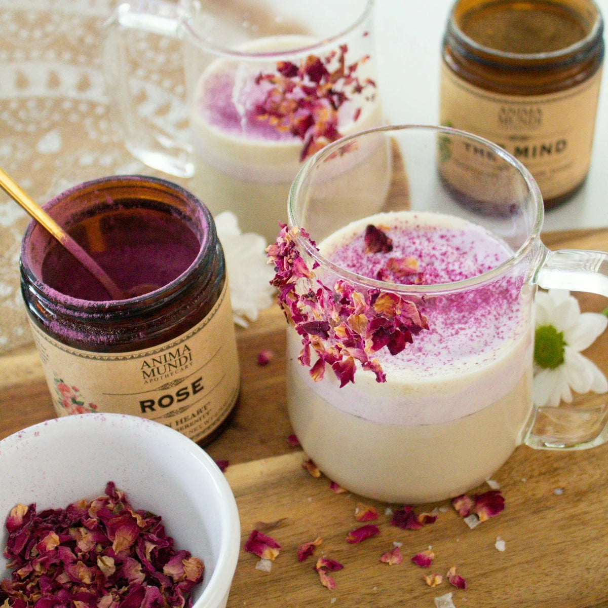 Anima Mundi Rose Powder jar beside rose lattes topped with dried rose petals