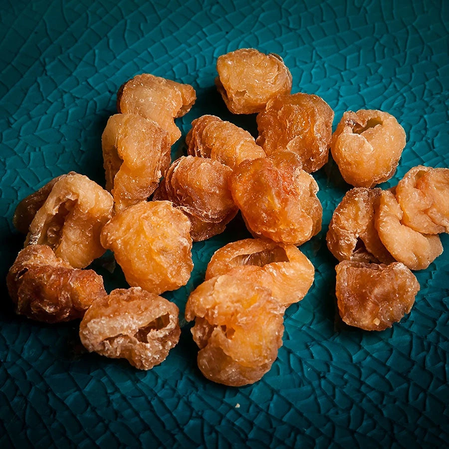Dried longan fruit on a teal plate