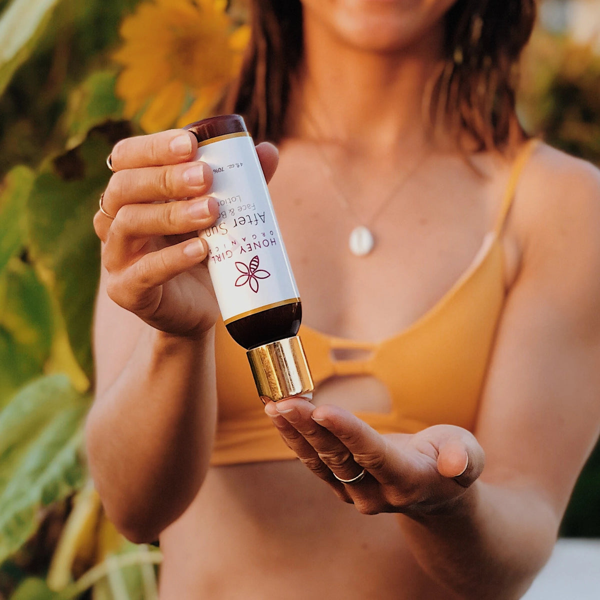Woman pouring Honey Girl Organics After Sun Face & Body Lotion into her hand